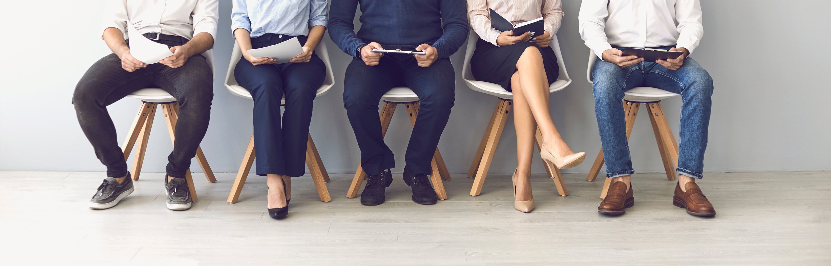 Group of Unrecognizable Candidates Sitting on Chairs Waiting for an Interview.